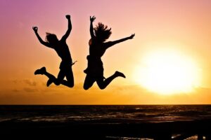 new year background, sunset, beach, silhouettes, jump, jumping, youth, active, happy, pair, girls, young women, people, joy, nature, freedom, seaside, dusk